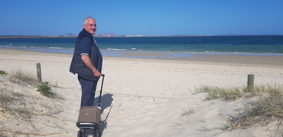 Man on a beach with oxygen concentrator